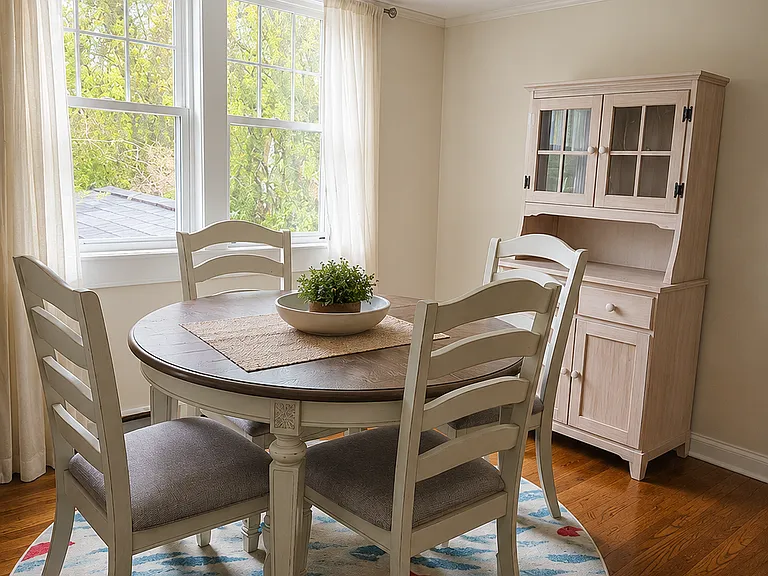 The dining area is hard wood floors and large enough to accommodate a round table and sideboard. Southern facing windows are great for natural sunlight. (AI Generated for Scale.)