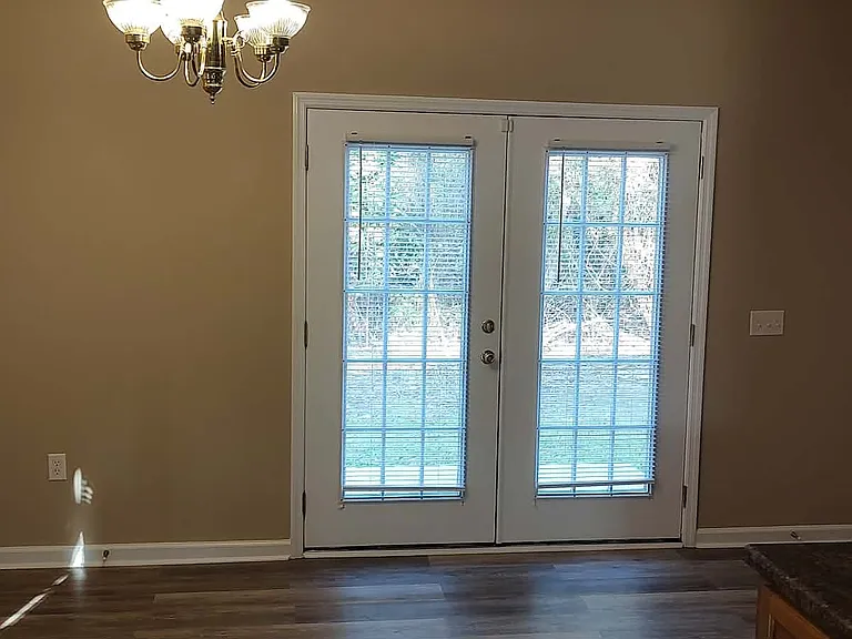 Eat-in kitchen with French doors leading to back patio.