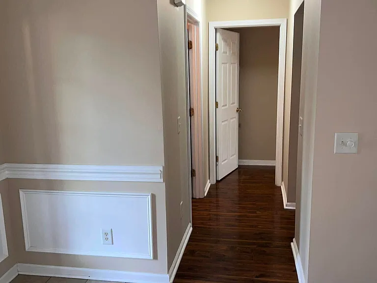 Hallway to Master Bedroom. Kitchen entrance on the right. Laundry room entrance with garage door entrance on the left.