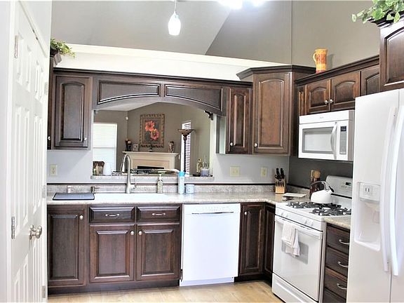 Kitchen with pass thru to living room. All cabinets are custom made by the Amish. Large two door pantry with plant shelf.