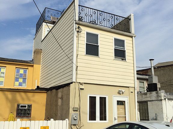 Back of house with parking pad