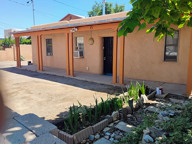 Front of house with covered porch and parking space.