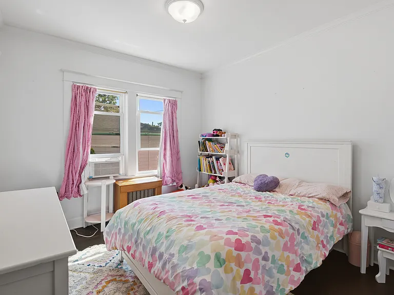 Bedroom with hardwood floors and oversized window