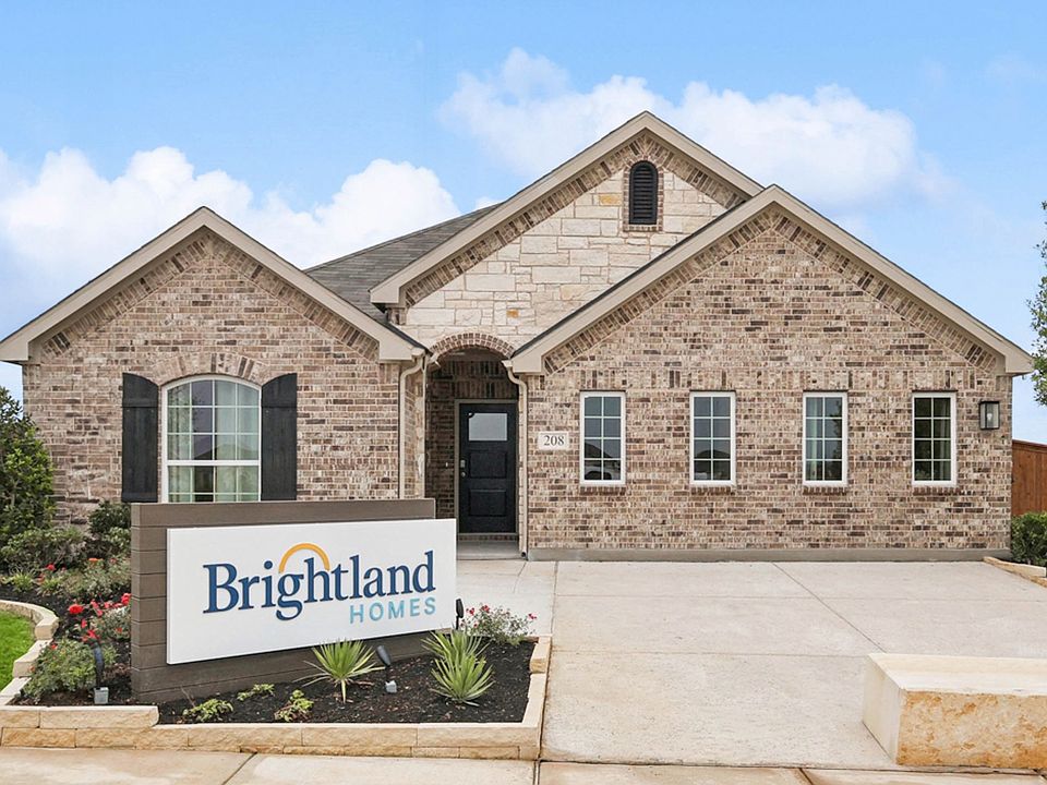 Elegant brick facade with arch details in Still Water Lake Estates. Distinctive landscaping enhances