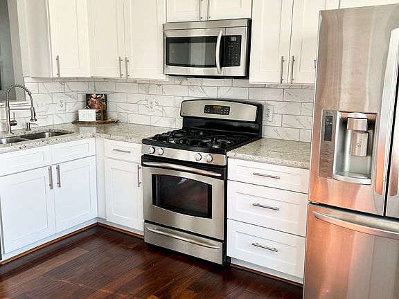 Modern kitchen with stainless steel appliances & gas stove