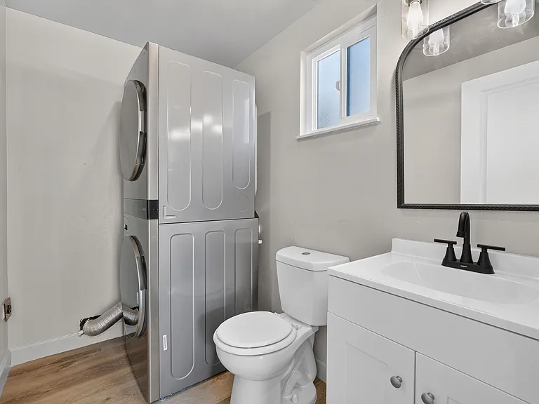 Downstairs 1/2 bath and laundry room. Stacked large capacity washer & dryer included.