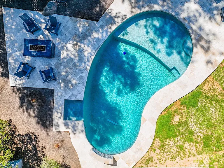 Pool, beach step, gas fireplace, sitting area.