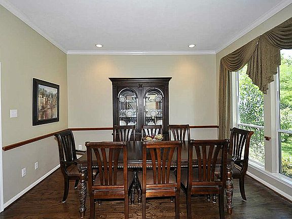 Formal dining room with warm hardwood floors & chair rail
