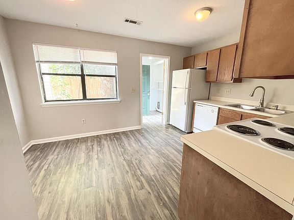 Eat in kitchen with separate laundry room beyond overlooking back patio.