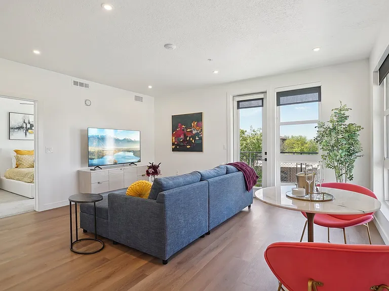 Liberty Duet Apartments, Salt Lake City, Utah; A living room with a blue couch, a red chair and a white table.