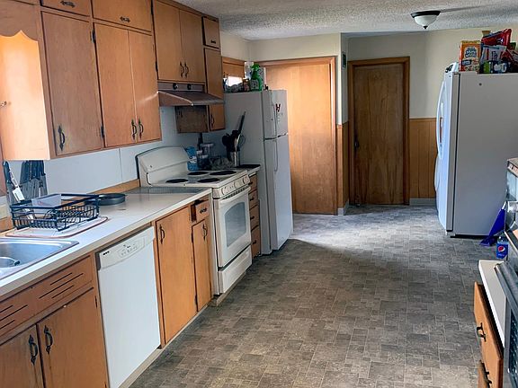 The large Kitchen features two ovens, two refrigerators, a dishwasher, and a new washer and dryer. A back door is located toward the back of the Kitchen.