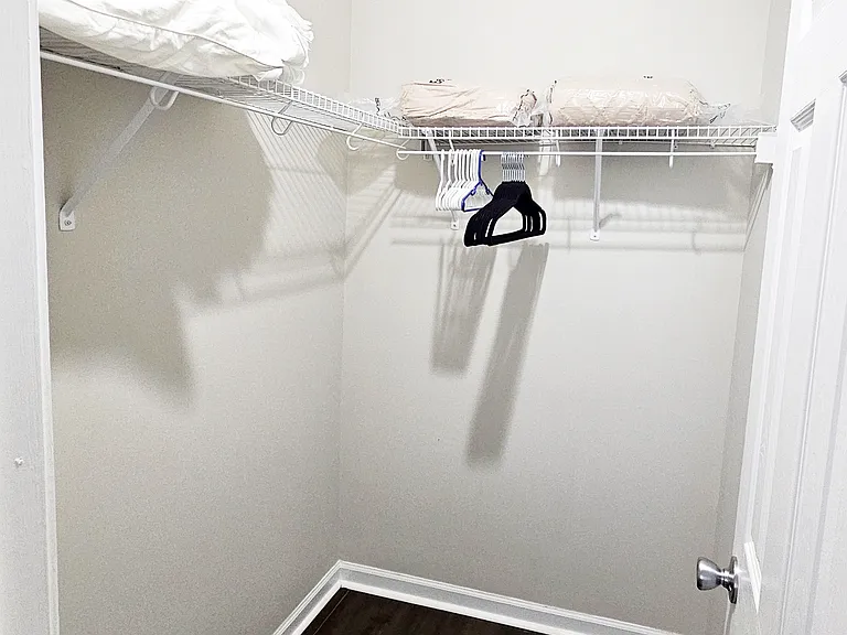 A nice-sized walk-in closet is attached to this room. There are extra hangers, linen, pillows, and blankets found here.