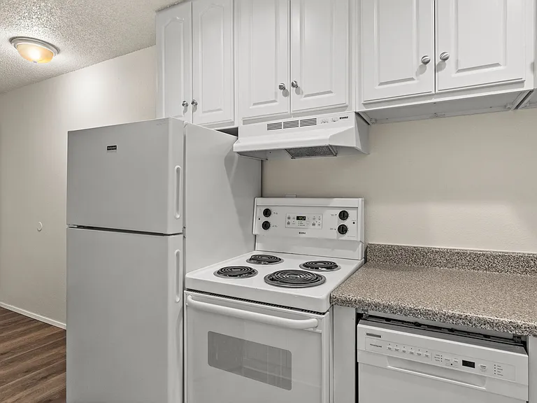 A clean and functional kitchen layout featuring white appliances, ample cabinet storage, and durable countertops_designed for everyday convenience. A clean and functional kitchen layout featuring white appliances, ample cabinet storage, and durable counte