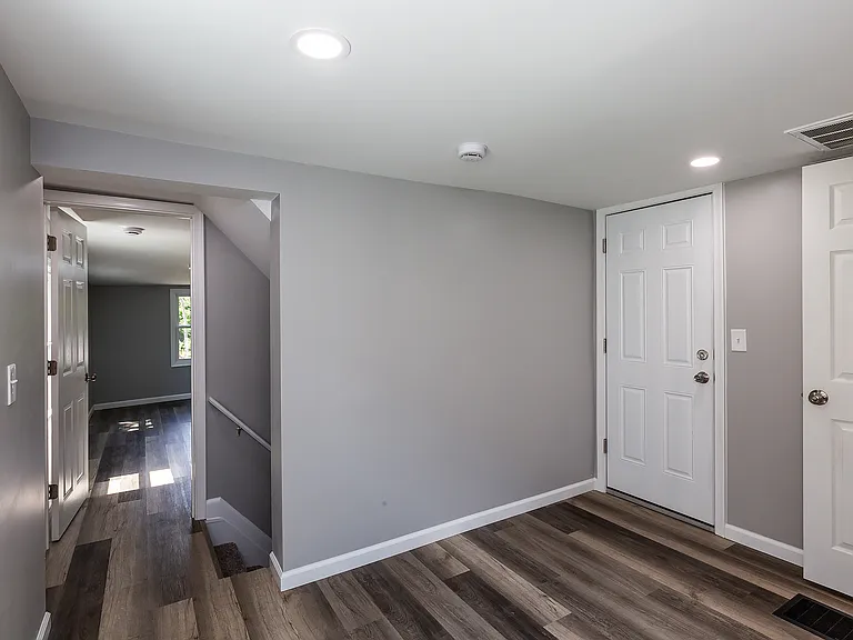 Outside front bedroom looking back. First door is bathroom, second door is attic, stairwell to first floor and in the back is back bedroom