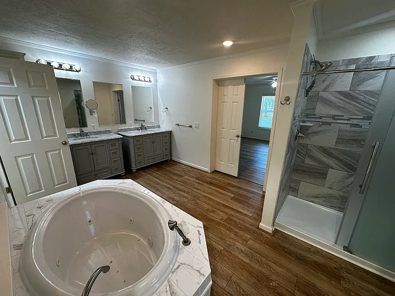 Master bath with Jacuzzi tub and movable shower head. His and her sinks.