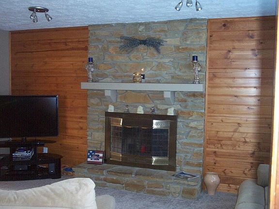 View of the Family Room Wood burning Fireplace and sleek knotty pine wall.