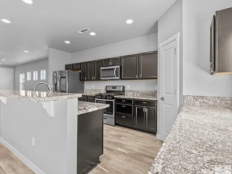 Kitchen has granite countertops, dishwasher, builtin range, pantry, garbage disposal, new refs