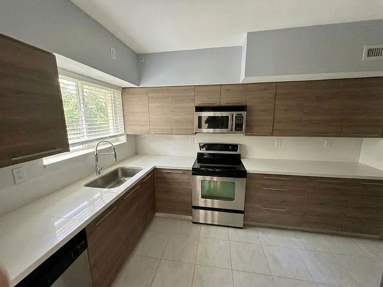 Kitchen (main angle)
Fully updated kitchen with flat-front wood cabinetry, stainless steel appliances, and quartz-style countertops