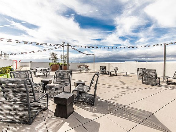 Rooftop terrace with seating and string lights.