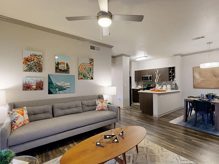 Apartment Kitchen with Stainless Steel Appliances, Dining and Living Room with Wood-Style Flooring.