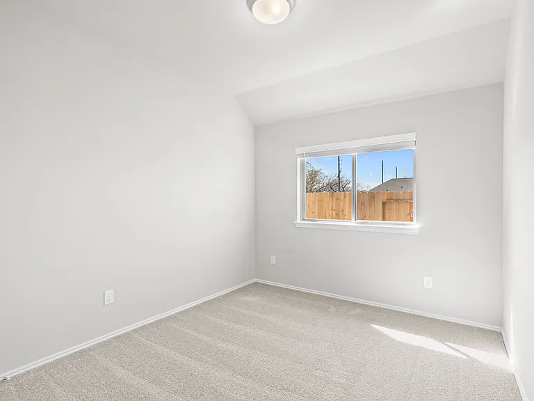 Secondary bedroom with carpet, natural light from backyard-facing window, and ample space.