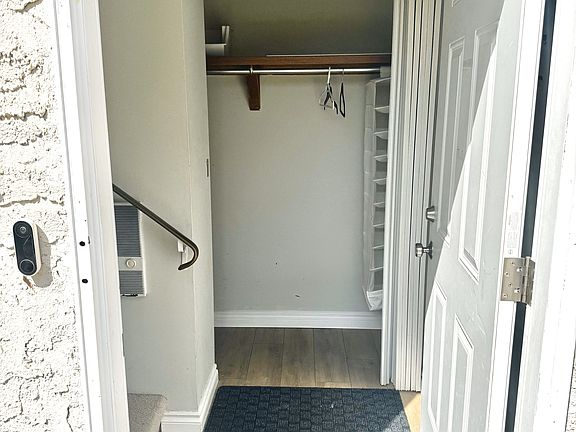 Front door with Nest doorbell camera, foyer entrance with spacious crawlspace storage next to the coat closet.