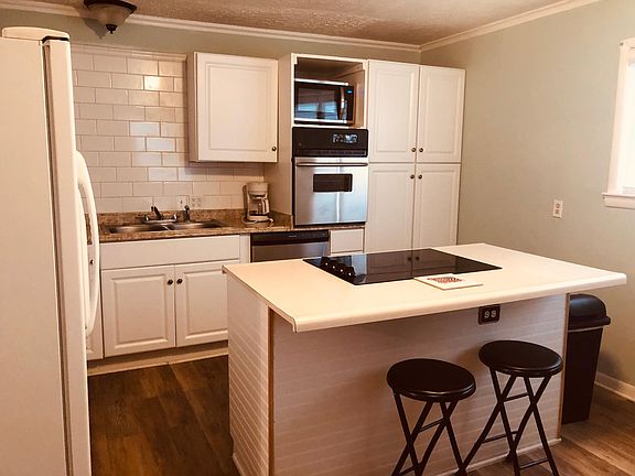 Updated kitchen with subway tile, stainless steel dishwasher, oven and microwave. Island with seating plus dining area.