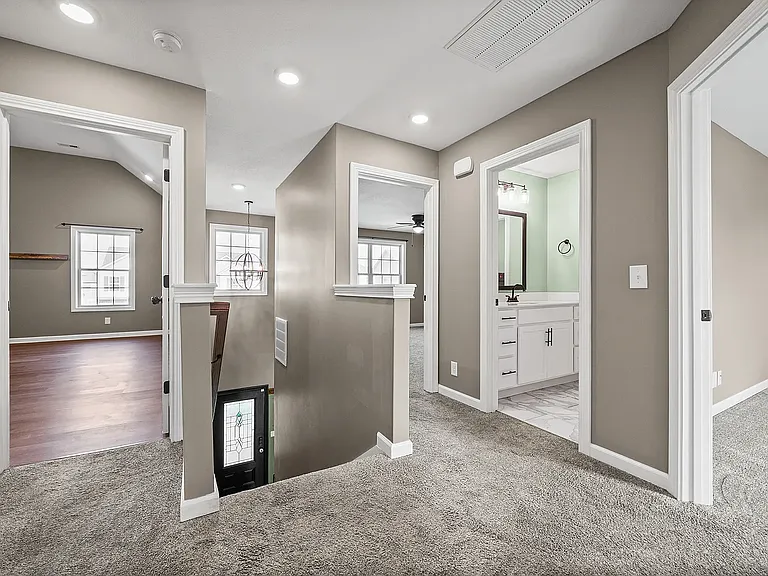Top of the stairs. From this view point the right doors are bedroom 4, bathroom, bedroom 3. Laundry room is directly across from stairs, followed by bedroom 2 and then the bonus room.