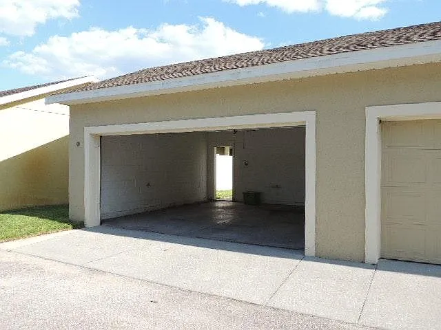 2 Car Garage with attic stairs / storage. This is an older photo just showing the door open and the space. Back doorway goes into back yard. Building has been painted since this photo.