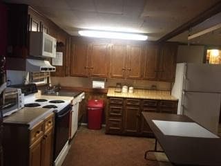 FULL KITCHEN W/ 2-DOOR FRIDGE/FREEZER, 30" RANGE W/OVEN, MICROWAVE, TOASTER OVEN, DISHWASHER, AND ISLAND WORK/BUFFET SERVING TABLE.