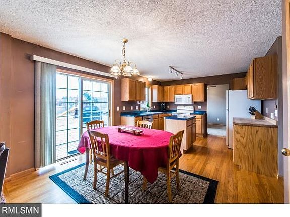Kitchen and informal dining space with patio door leading out to ground level level deck and fenced in yard