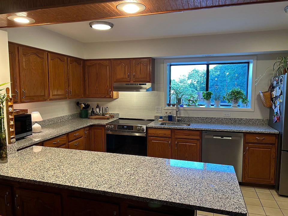 Kitchen with new oven, dishwasher, refrigerator, countertops and sink.