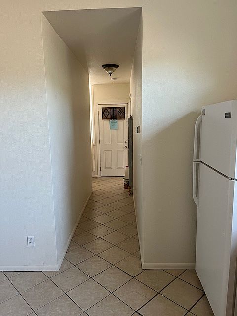 Kitchen looking towards back door, bathroom and back bedroom and laundry.
