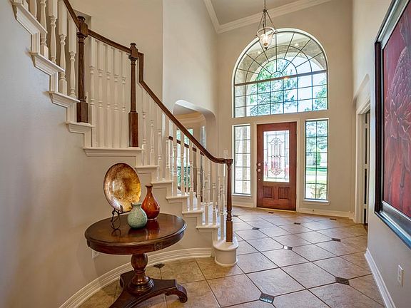 The large 2-story entry has ample space to welcome guests and light reflects through the expansive windows above and next to the entry door.