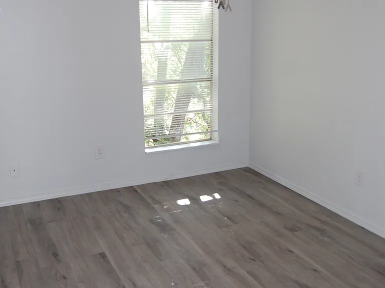 Bedroom with ceiling fan and blind.