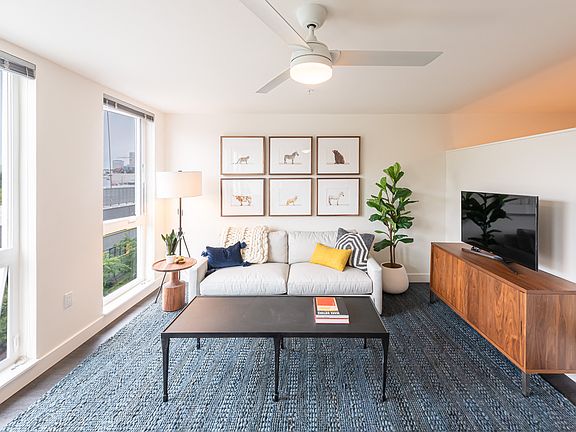 Living Room with Floor to Ceiling Windows and a Ceiling Fan