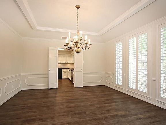 The formal dining room can seat a crowd and is highlighted with chair rail and wainscot moldings, plantation shutters and a beautifully framed tray ceiling.