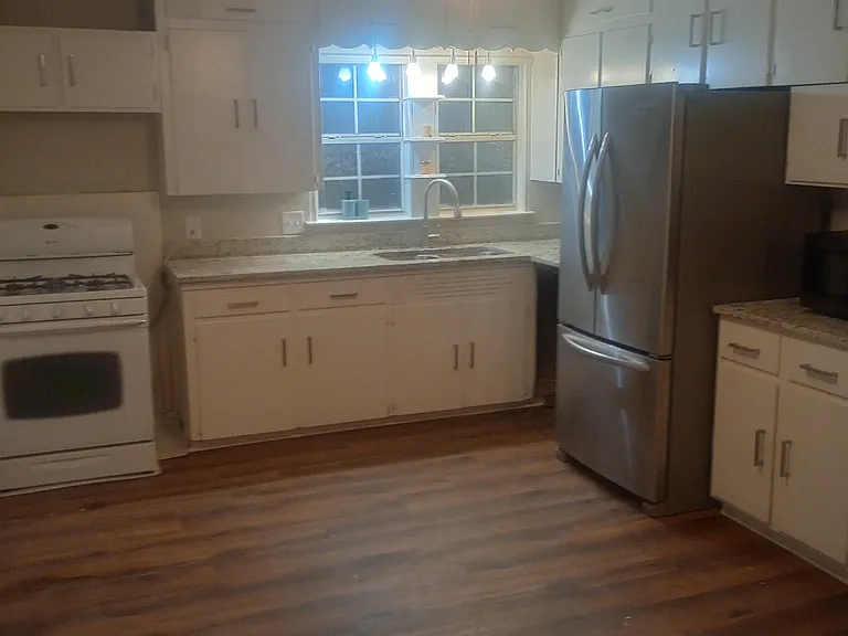 Kitchen, completed remodeled with laminate flooring, ceiling fan, stainless steel gas stove with microwave and vent-a-hood (not pictured), refrigerator (2 year old), dishwasher, and garbage disposal.