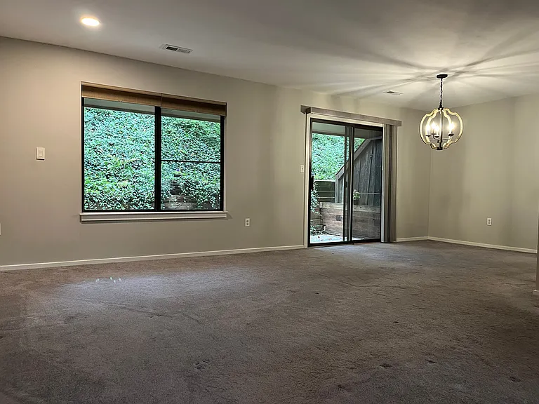 Open living room space with updated sliding door opening to enclosed rear yard