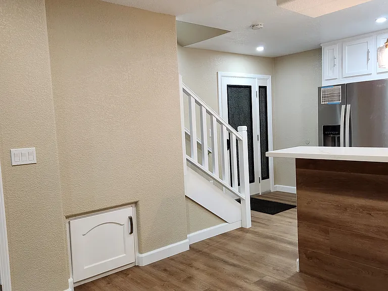 View toward stairwell and front entrance from living room.