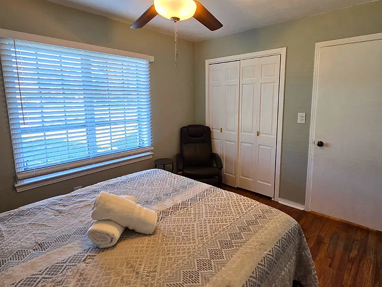 Relaxing bedroom with great lighting, soft pillows, and fresh towels