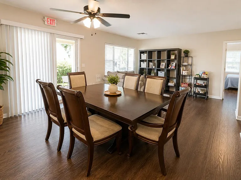 Spacious dining area with a full-size table, durable flooring, and easy access to the living space and patio door.
