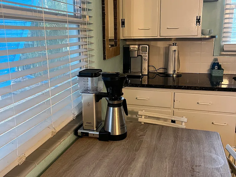 Kitchen nook with high filtered coffee maker as seen in "Free Guy" and a Keurig machine for your favourite brew.