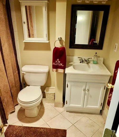 Full bathroom features shower curtain, rugs, and towels