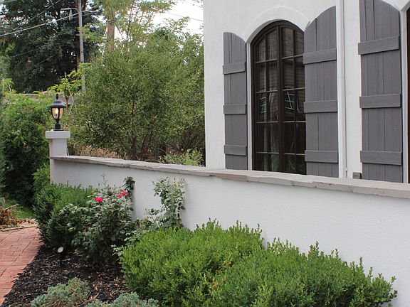 Mature gardens with fragrant plantings and large evergreen trees for privacy.