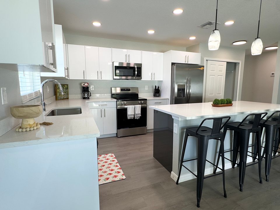 Open-concept kitchen with sleek finishes and an island overlooking the living and dining space.