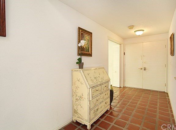 Formal entry way with Mexican pavers. Door to the right of the double entry doors leads to the master suite. The door on the left leads to the attached two car garage.