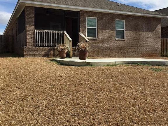 View of back yard, patio, and screened porch.