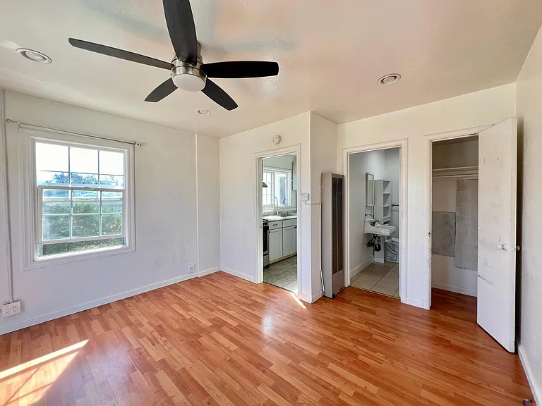 Laminate flooring in living/sleeping area and tile flooring in kitchen and bathroom