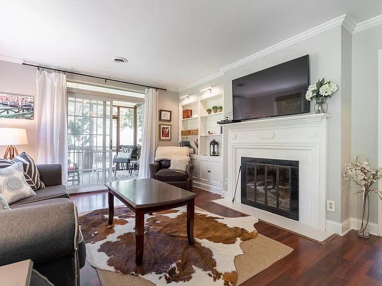 Living room with fireplace and sliding glass door to screened porch.